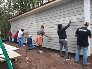 Volunteers paint the exterior of 1207 Elm St.
