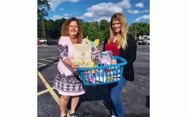 NESPA President Marian Phillips and Nassau County Schools Families in Transition Program Director Mollie Cressey hold up a basket filled with donations going to benefit a struggling Nassau County family this Easter. Submitted photo