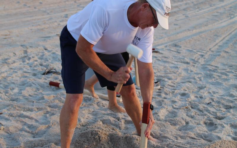 Amelia Island Sea Turtle Watch volunteer Eric Linden hammers a stake into the sand, marking the area surrounding the nest he and his wife Jan found earlier that morning.