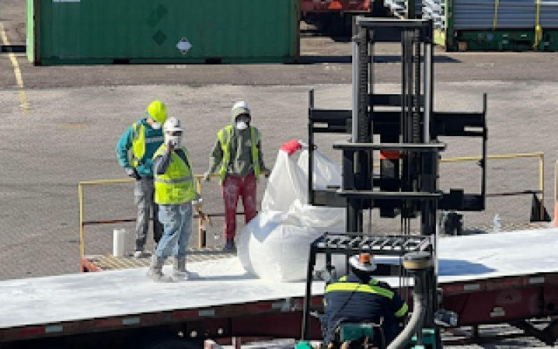 Workers wrap damaged bags of cement with plastic. Nassau Terminals said the spillage will be cleaned up using vacuums, and that drains will be protected to keep the material from getting into groundwater. Submitted photo