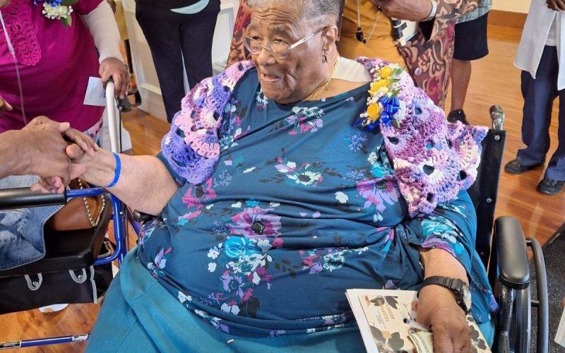 Fellow classmate Elizabeth Harvey Robinson presented a knitted shawl and hat to Johnnie Mae Van. Photo by Maybell Kirkland