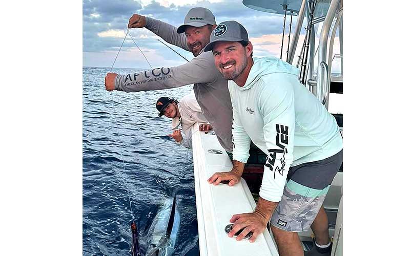 Carter Thrift, left, caught and released this estimated 250-pound blue marlin while fishing with Jeff Scott, center, and Kyle Coker, right, during a recent fishing trip in the Bahamas. Submitted photo