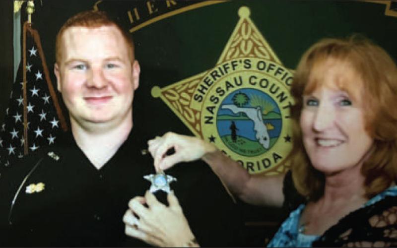 Brenda Moyers pins Josh Moyers’ badge on as he begins his career as a deputy with the Nassau County Sheriff’s Office. Moyers’ family shared the photo as victim impact statements were read in court last week. Submitted photo