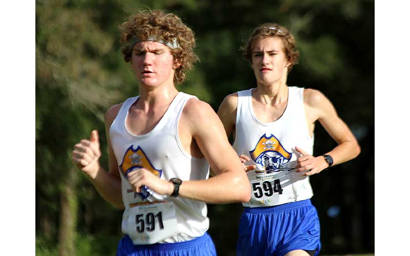 Adalai Kwaitkowski, left, was left shoeless from the mud Saturday at Cecil Field. Junior Paul Wetherhill, right. Photo by Stephanie Nichols/Special 