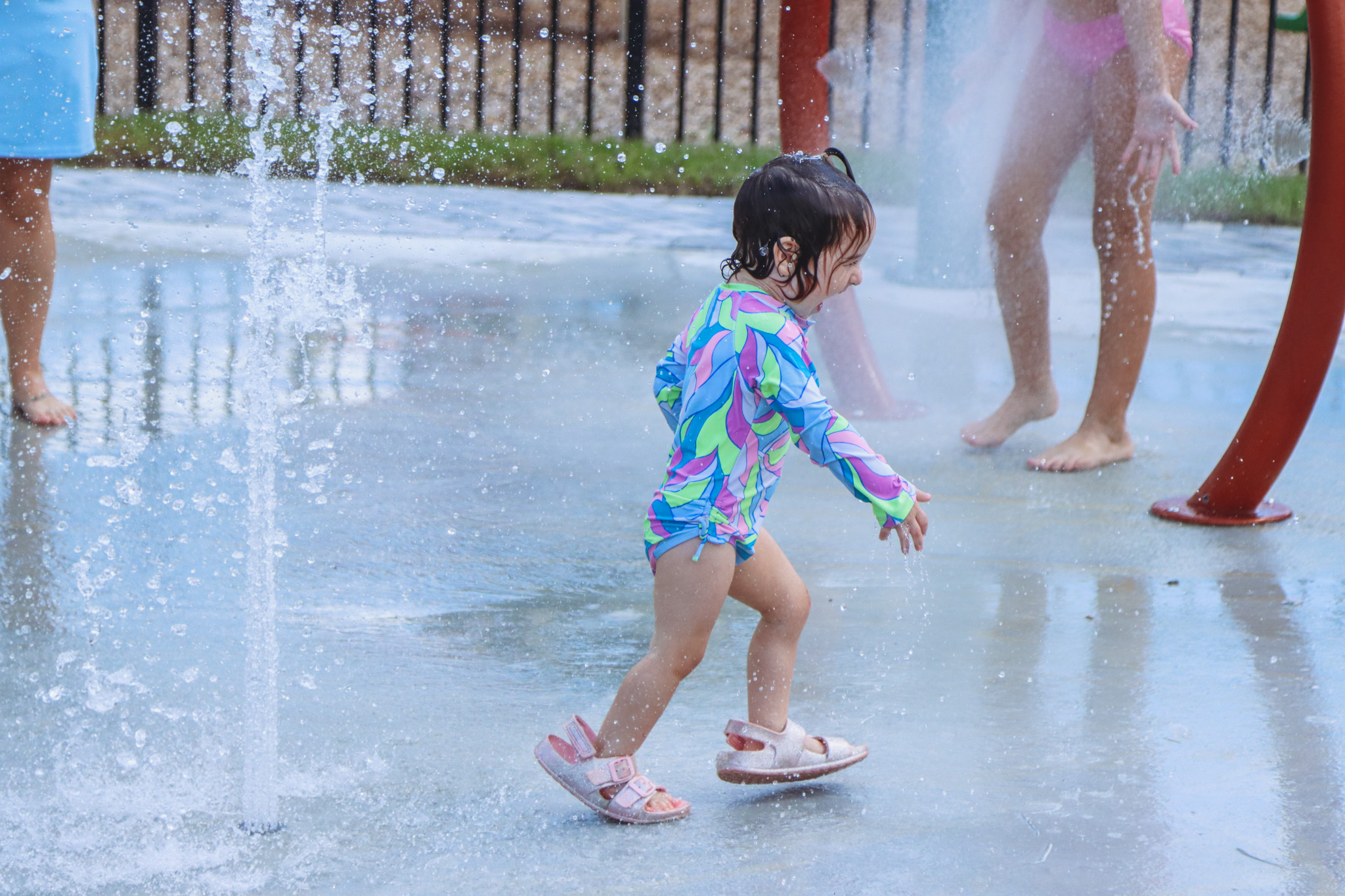 Kids play at the splash pad, the new amenity at Nassau Crossing Park, after its official opening Sept. 26. Photo by Ashley Chandler/News-Leader