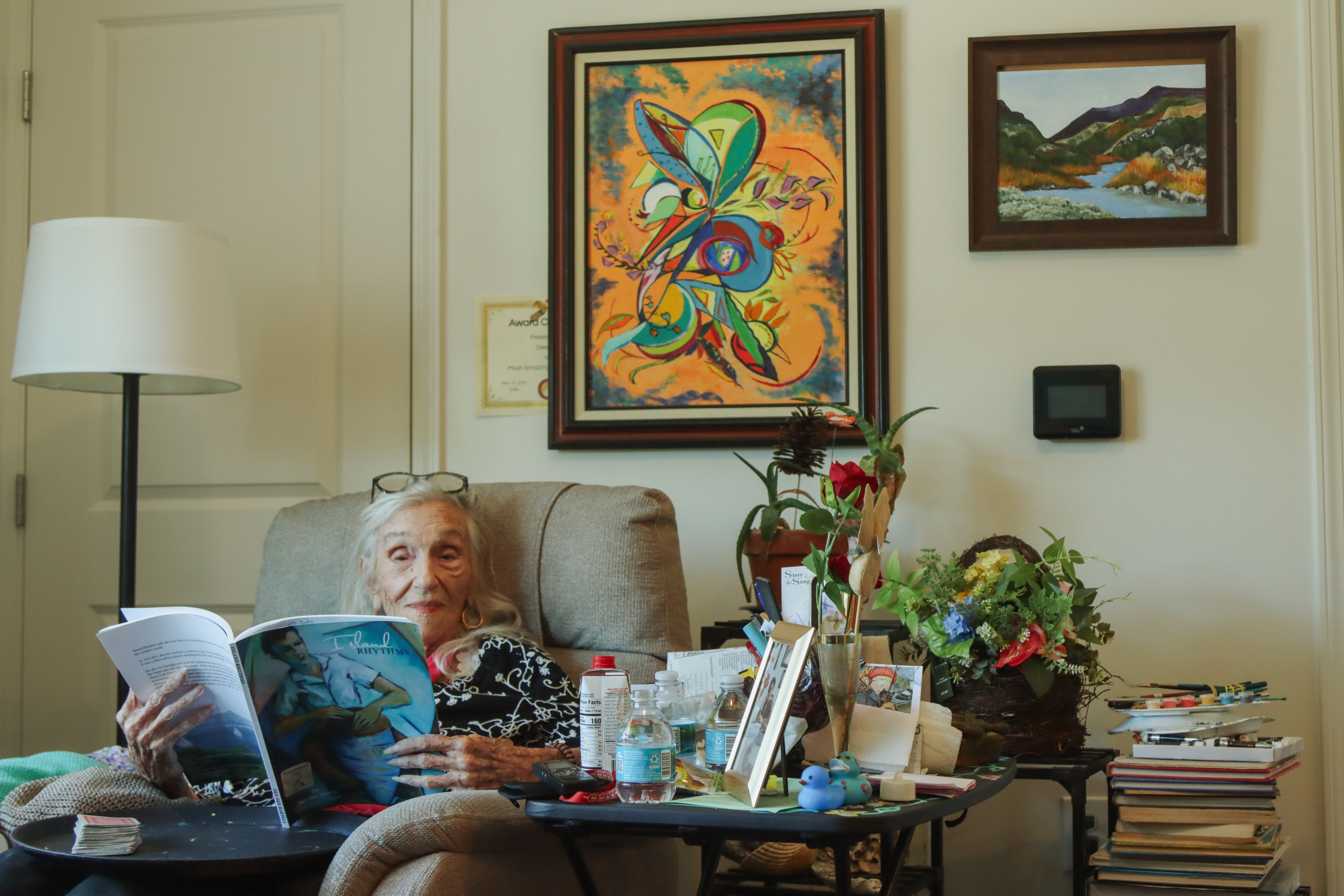 Dee Dee Bartels flips through one of the books she authored during her long life in her apartment in Fernandina Beach in April 2025. Photo by Ashley Chandler/News-Leader