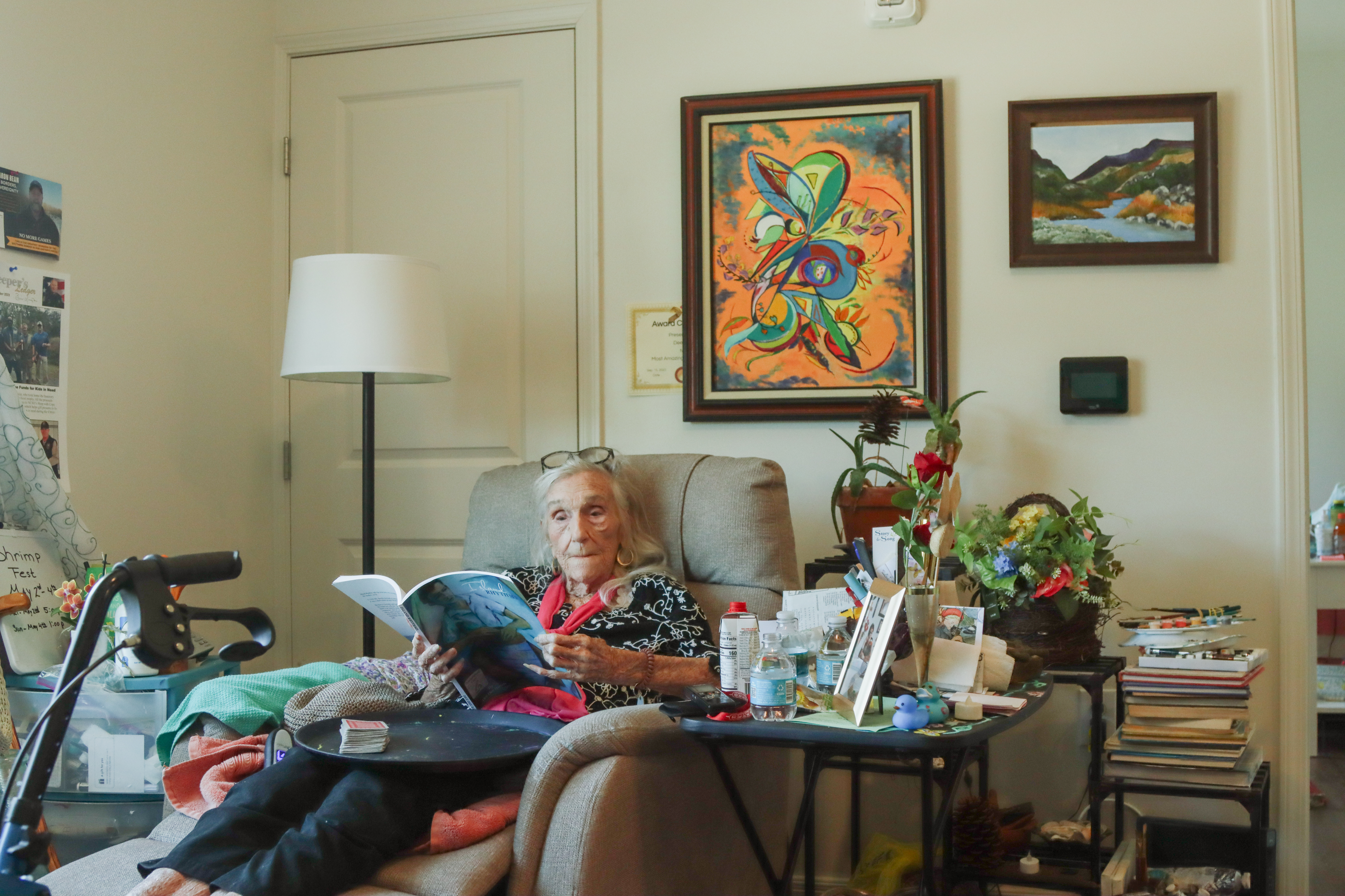 Dee Dee Bartels flips through one of the books she authored during her long life in her apartment in Fernandina Beach in April 2025. Photo by Ashley Chandler/News-Leader