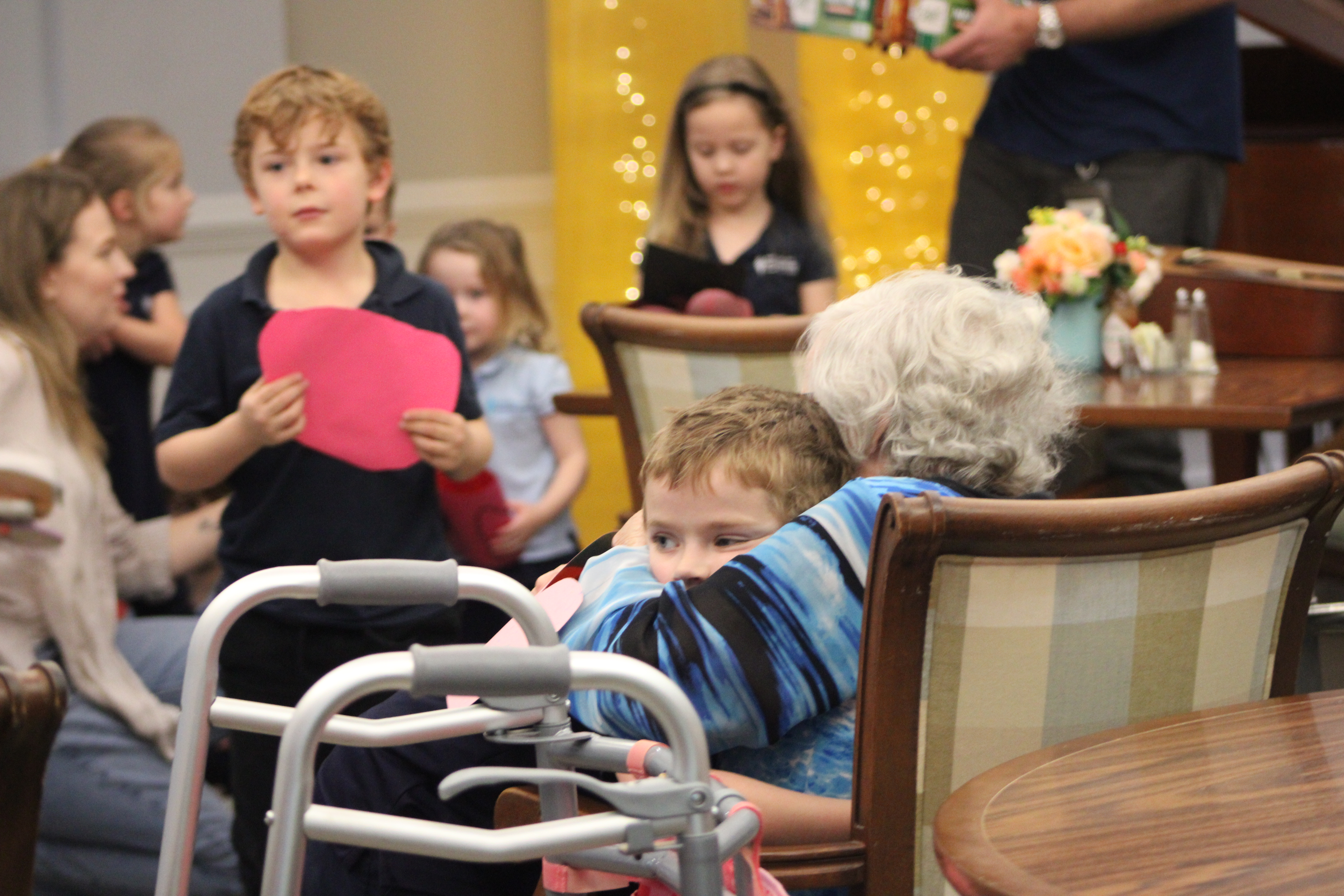  Osprey Village resident hugs Montessori student after he gave her a Valentine's Day card.  By Marisa DeMar/News-Leader