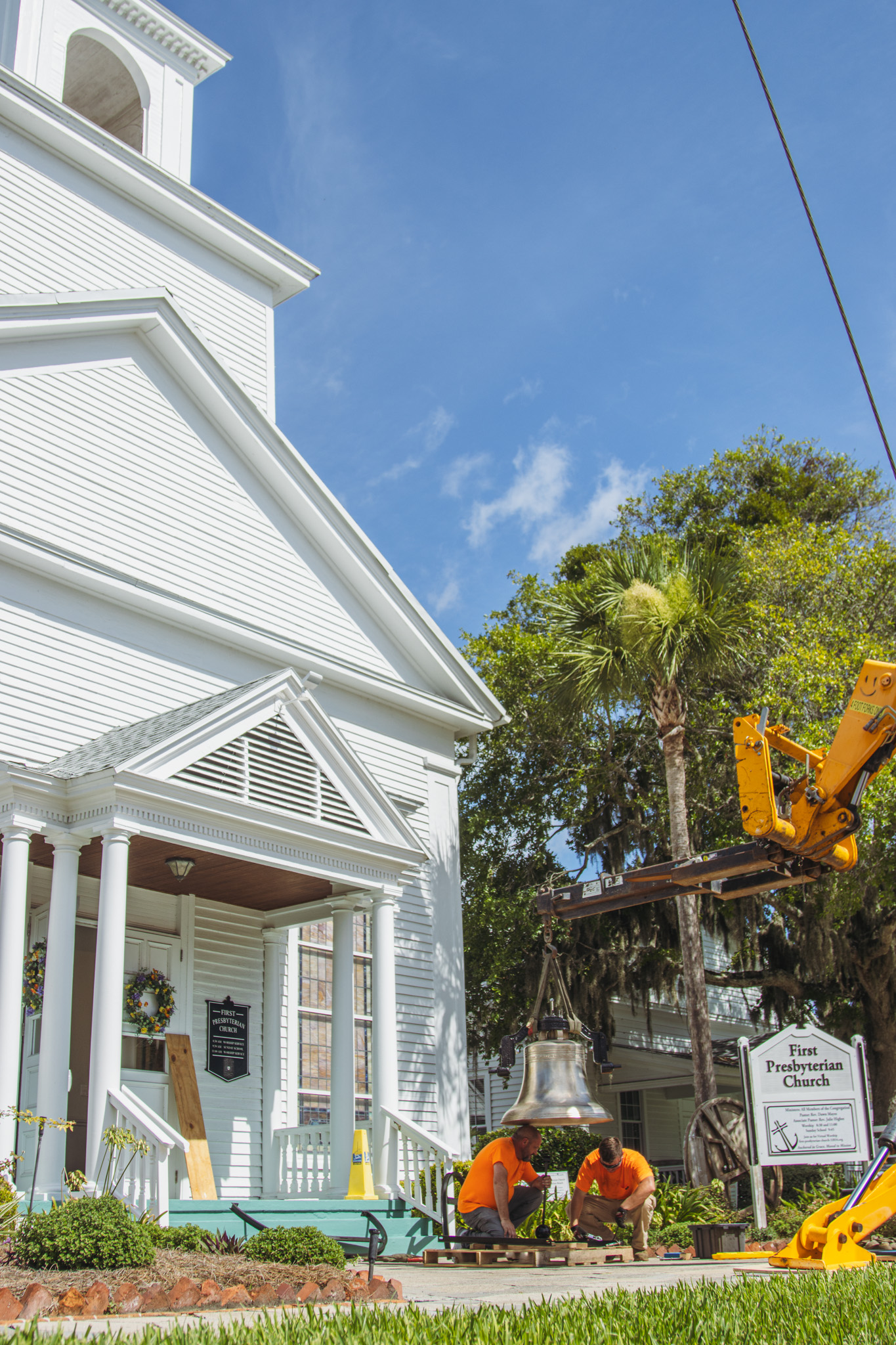 Workers from White’s Clock and Carillon assemble and place the restored bell in its place in the First Presbyterian Church belfry on Tuesday in Downtown Fernandina Beach. Photo by Ashley Chandler/News-Leader