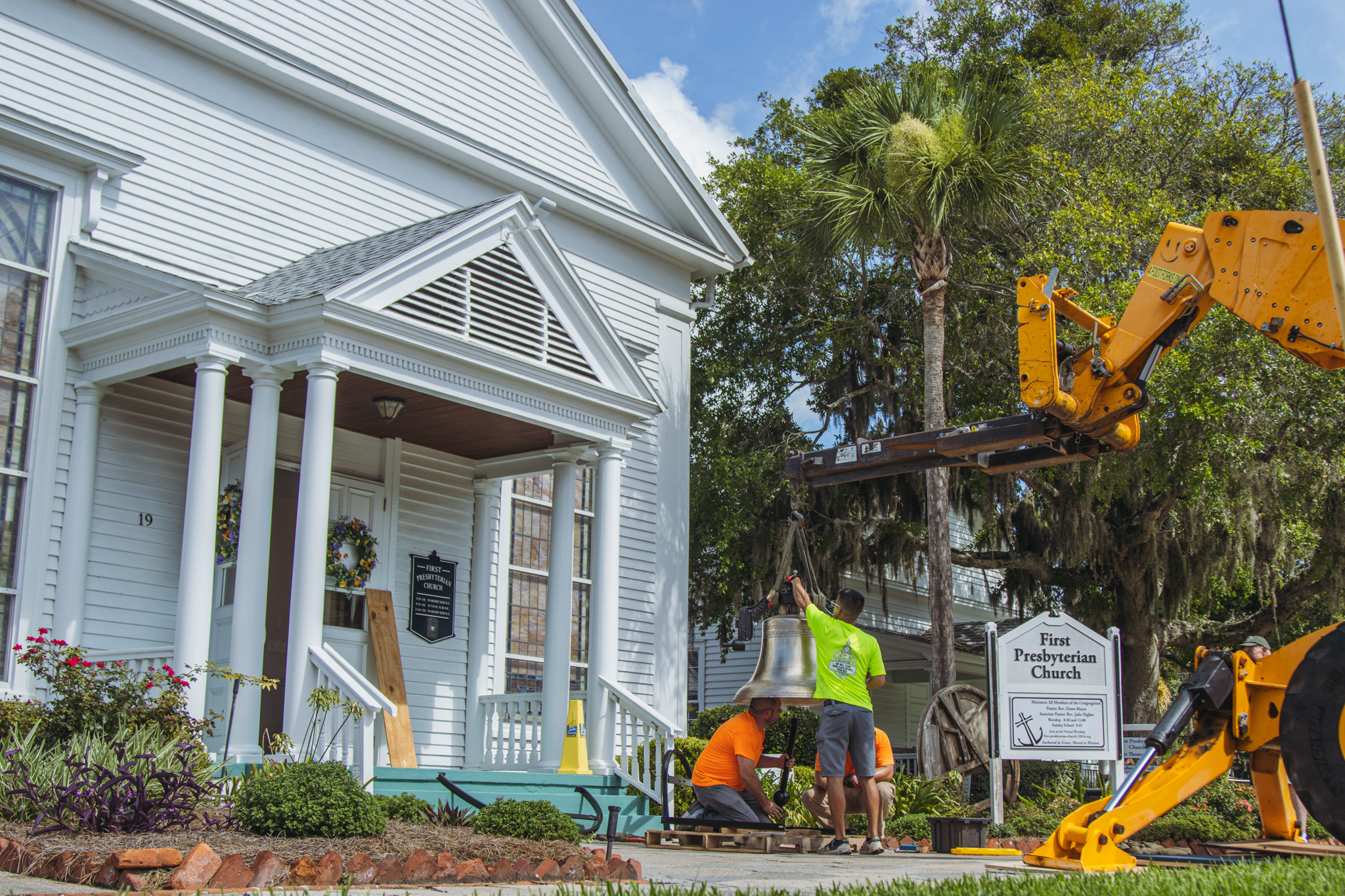 Workers from White’s Clock and Carillon assemble and place the restored bell in its place in the First Presbyterian Church belfry on Tuesday in Downtown Fernandina Beach. Photo by Ashley Chandler/News-Leader