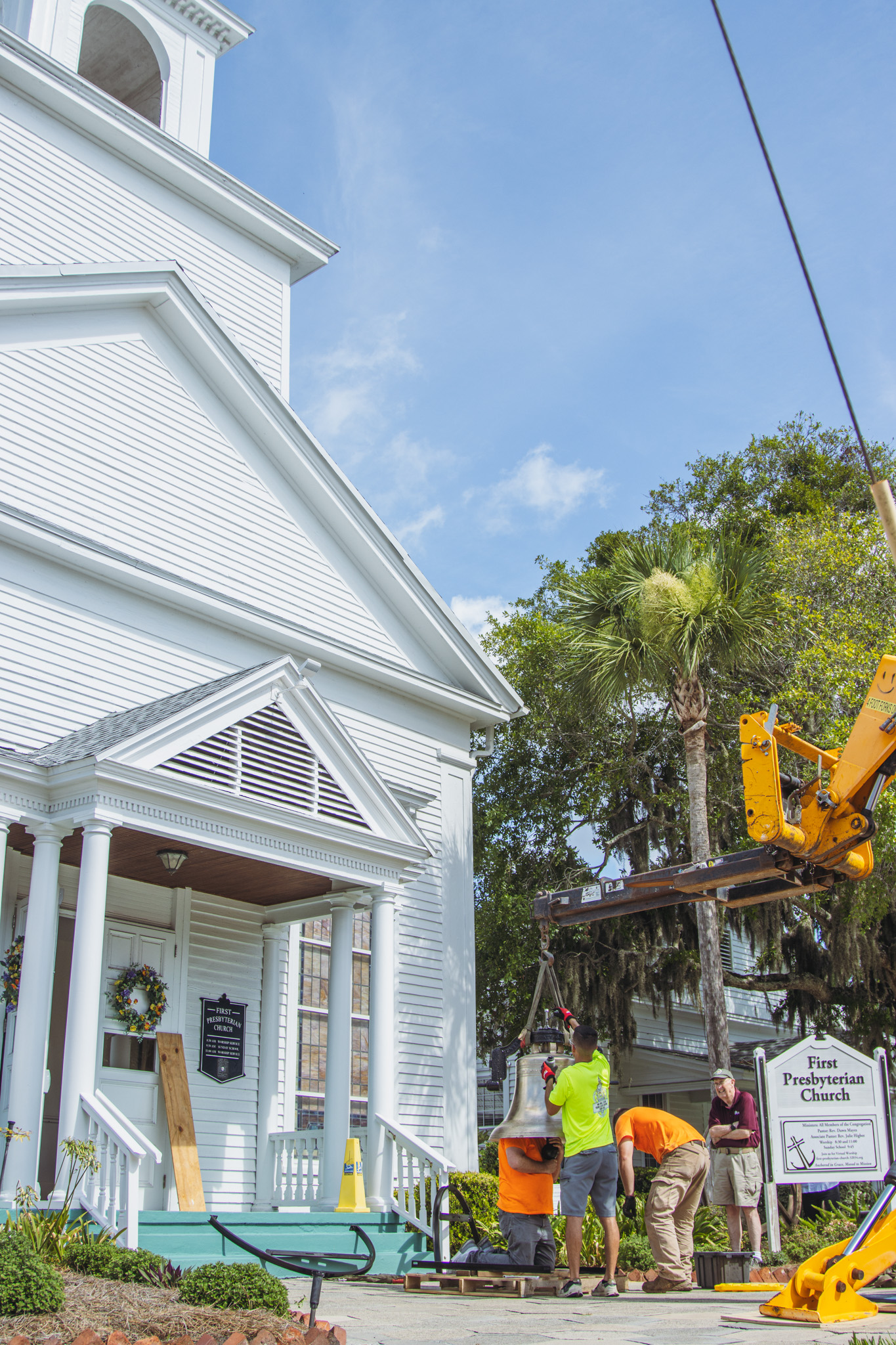 Workers from White’s Clock and Carillon assemble and place the restored bell in its place in the First Presbyterian Church belfry on Tuesday in Downtown Fernandina Beach. Photo by Ashley Chandler/News-Leader