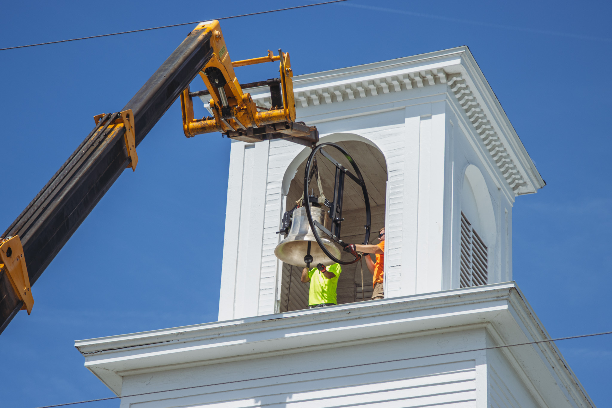 Workers from White’s Clock and Carillon assemble and place the restored bell in its place in the First Presbyterian Church belfry on Tuesday in Downtown Fernandina Beach. Photo by Ashley Chandler/News-Leader