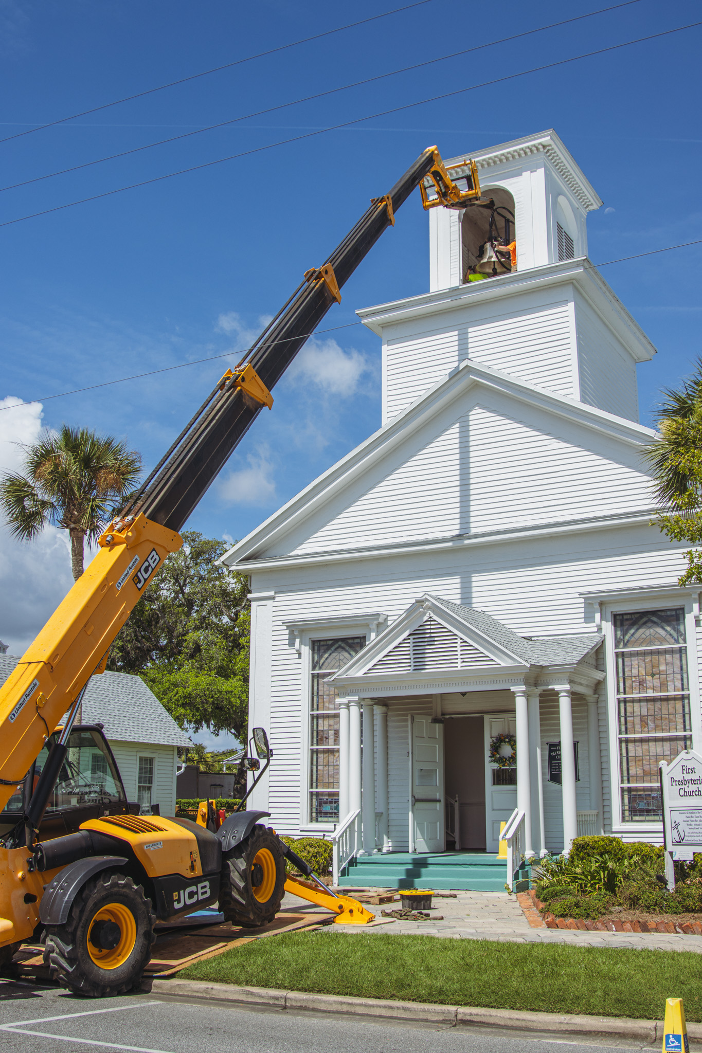 Workers from White’s Clock and Carillon assemble and place the restored bell in its place in the First Presbyterian Church belfry on Tuesday in Downtown Fernandina Beach. Photo by Ashley Chandler/News-Leader