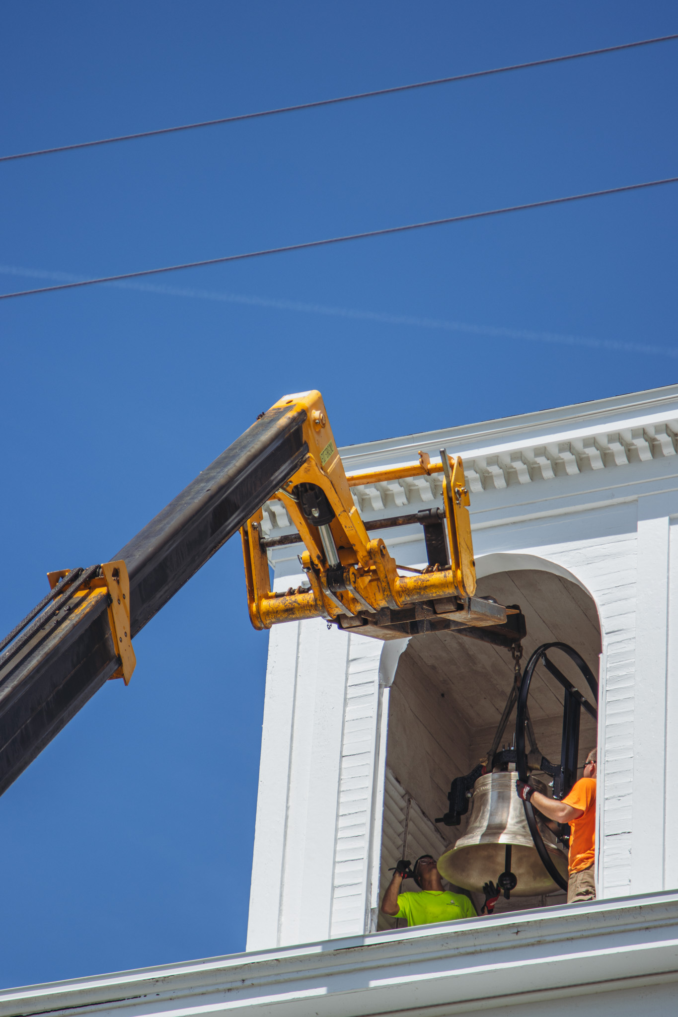 Workers from White’s Clock and Carillon assemble and place the restored bell in its place in the First Presbyterian Church belfry on Tuesday in Downtown Fernandina Beach. Photo by Ashley Chandler/News-Leader