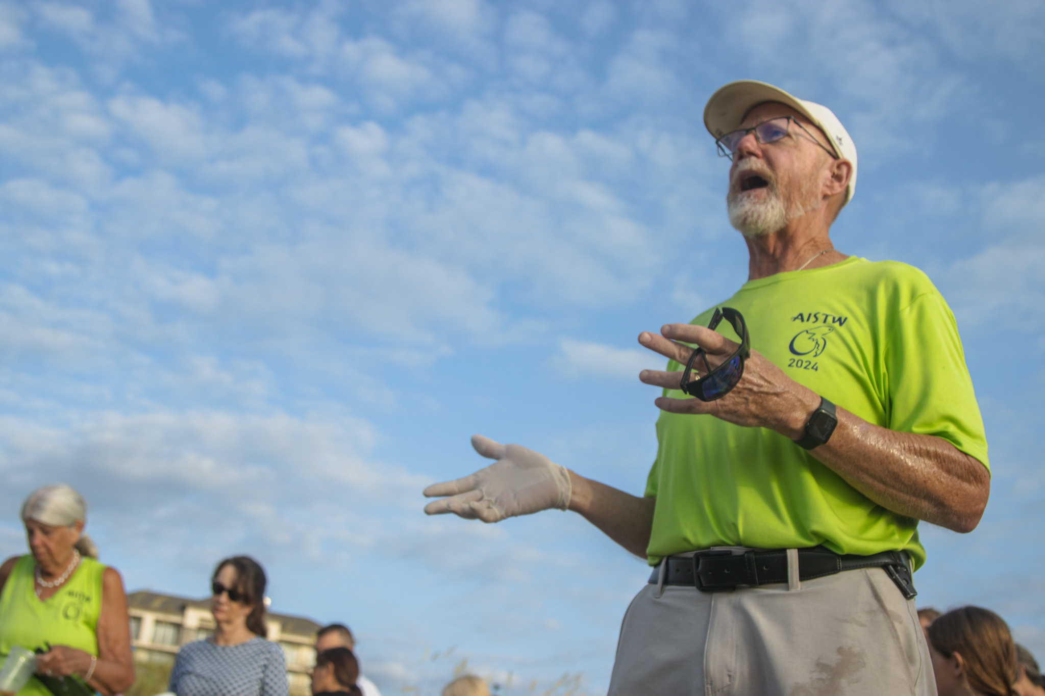Bill Bokram talks with people on the beach Friday about sea turtles and nesting season. Photo by Ashley Chandler/News-Leader