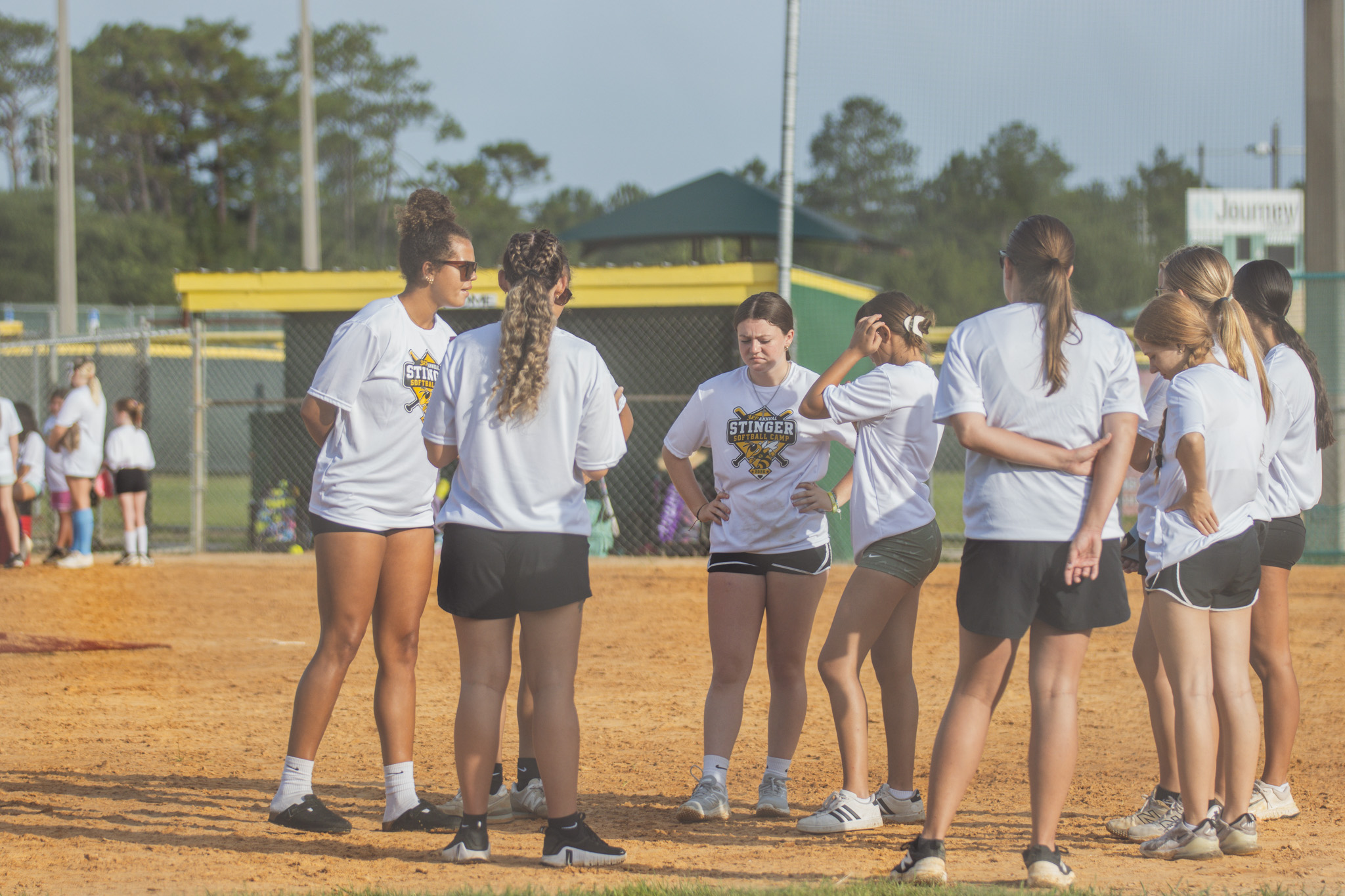 Yulee High School softball players and coaches huddle before camp particpants took the field for a game at Thursday’s camp. Photo by Ashley Chandler/News-Leader