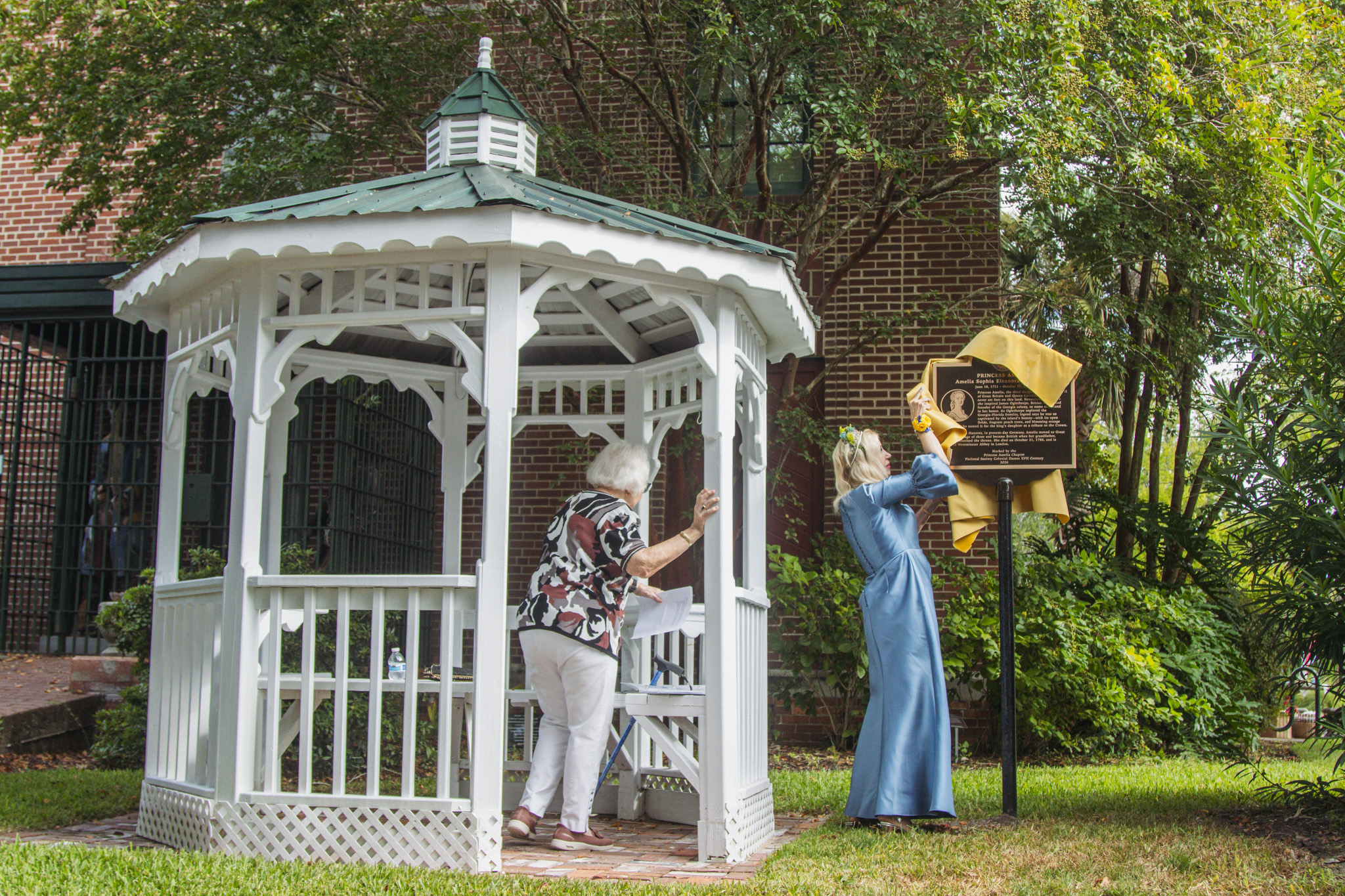 Lynn Leisy, president of the Princess Amelia Chapter of the Florida Society of the Colonial Dames XVII Century, and distant cousin to Amelia, unveils the Princess Amelia historical marker Saturday, now outside the Amelia Island Museum of History. Photo by Ashley Chandler/News-Leader
