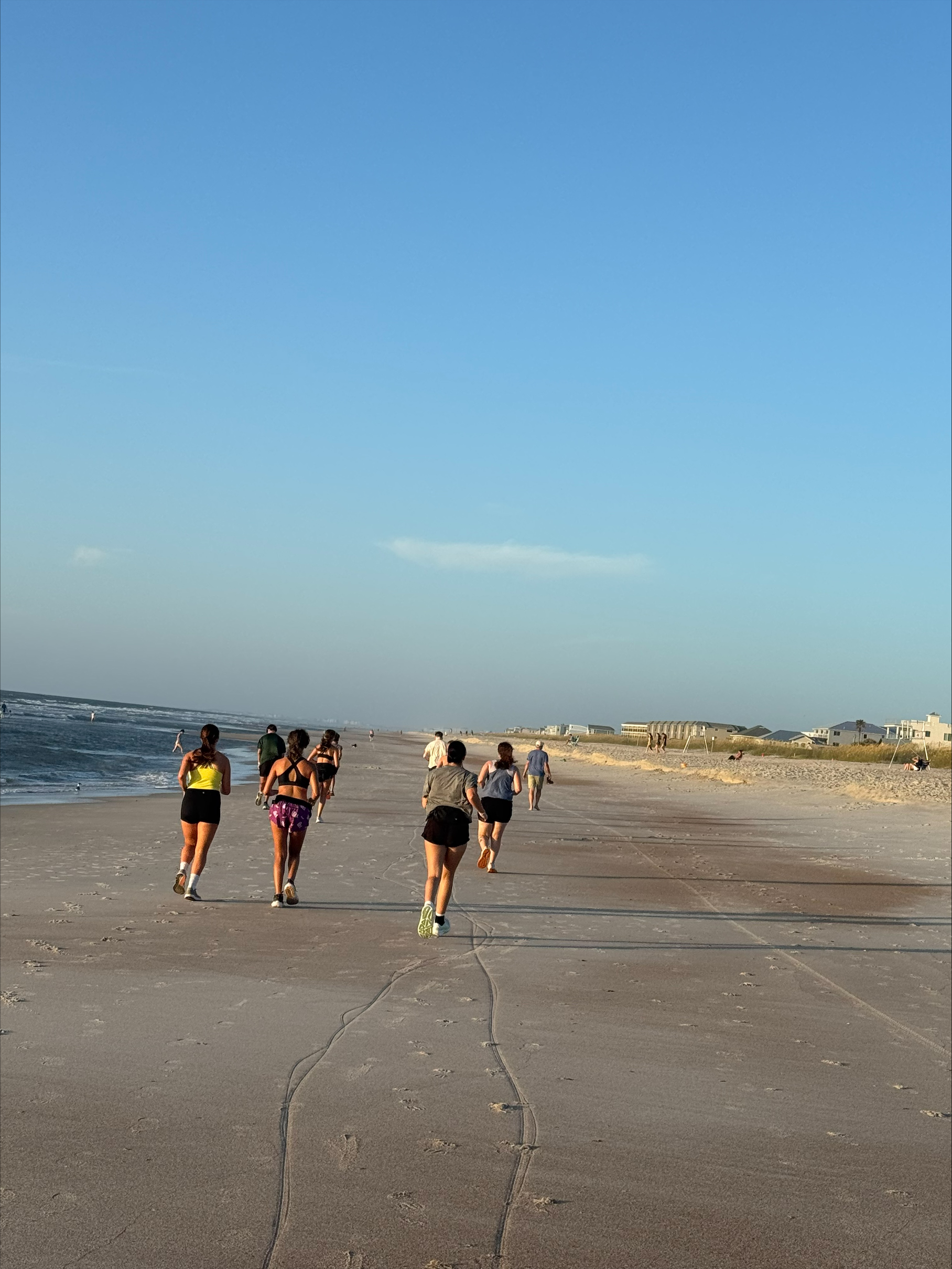Yulee High School boys and girls cross country athletes run on the beach during a summer training session. Courtesy of YHS cross country