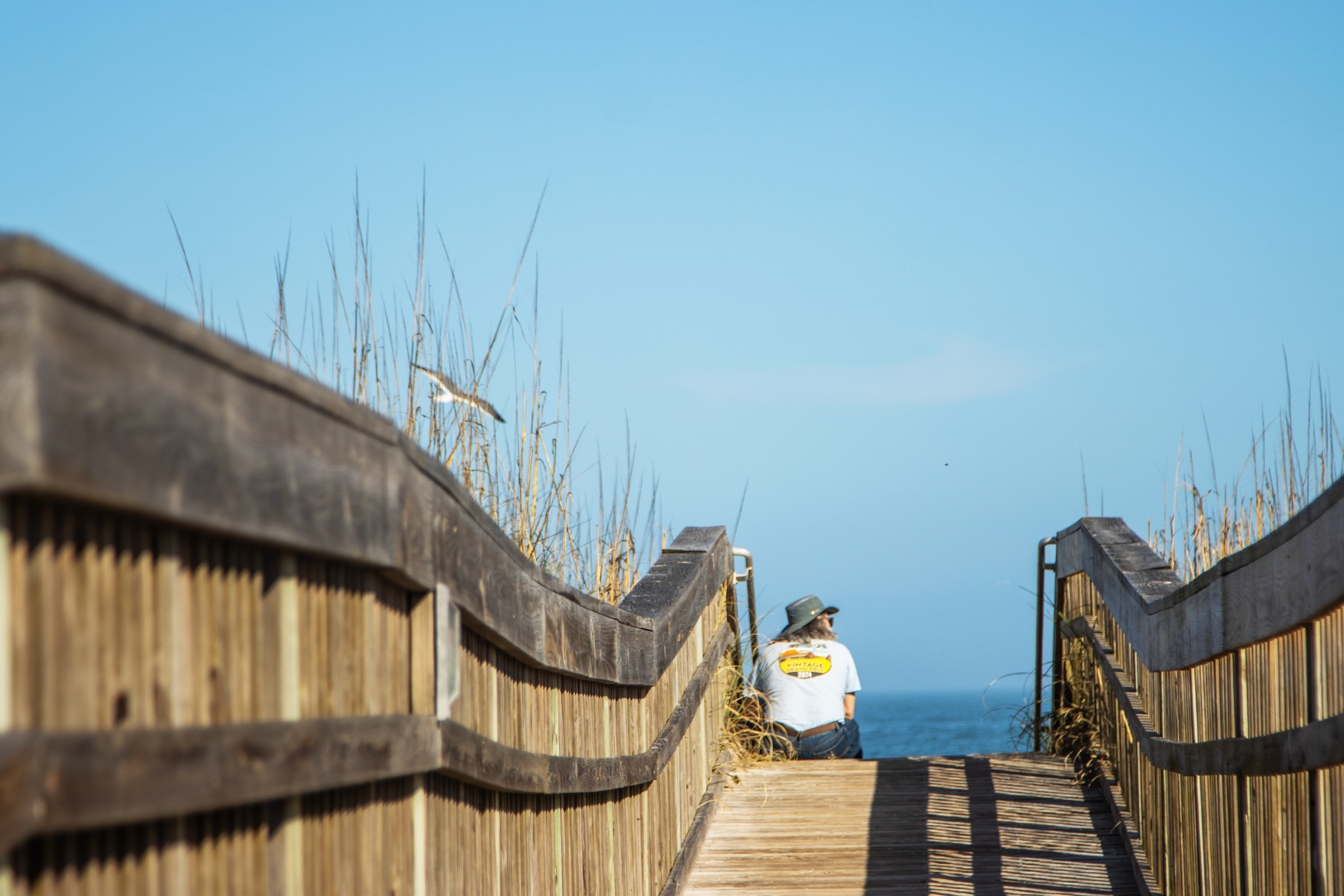 A man sits on a beach walkover at Main Beach earlier this year. The city is working with Kimley-Horn and associates, Inc. on a Parks Master Plan. Staff is focused on the needs for beach accesses and walkovers, and other recreation needs. Photo by Ashley Chandler/News-Leader