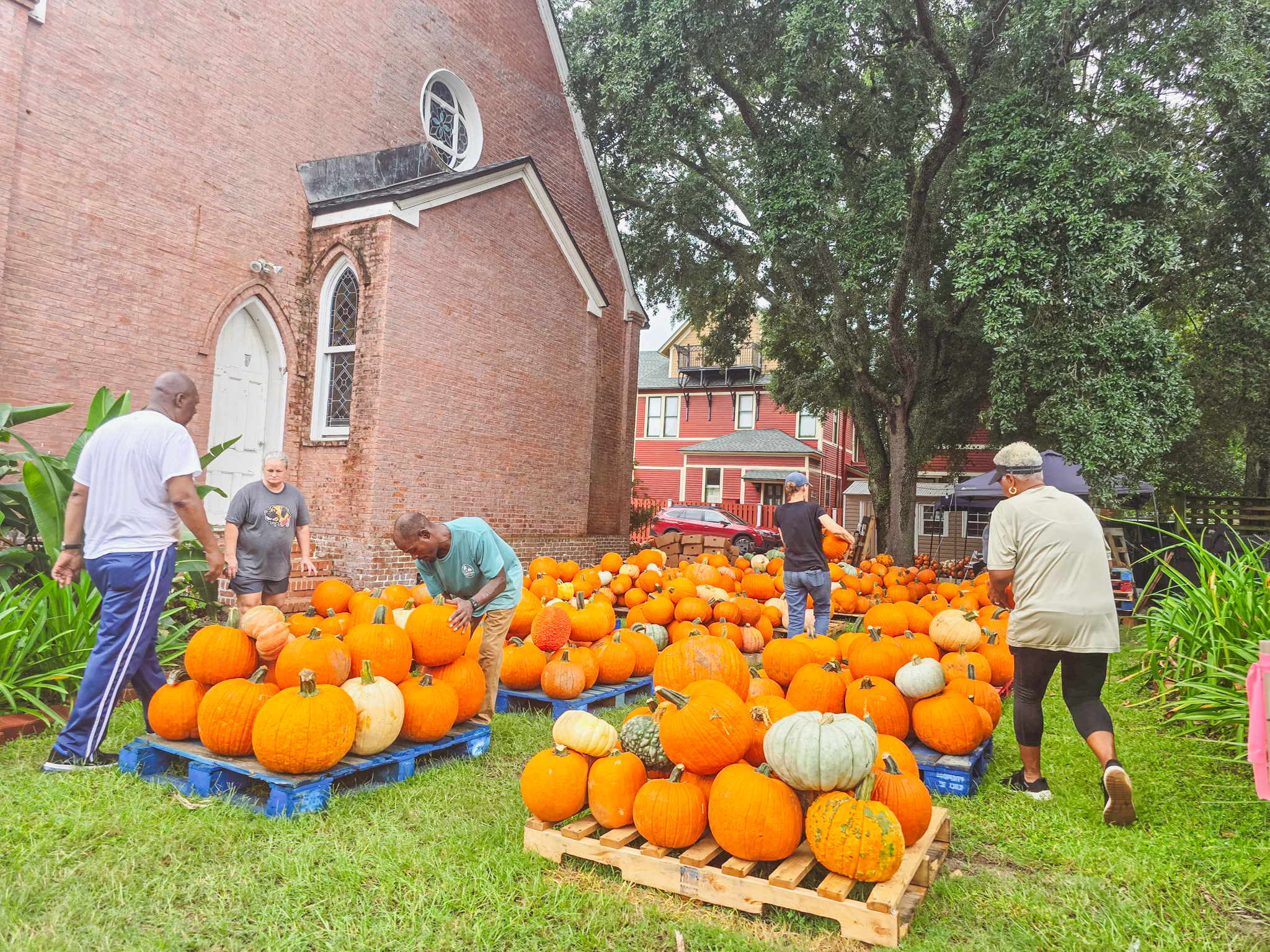 Serena Peterson, Trinity United Methodist Church outreach, far right, and Roschnell Brown, lay leader and the Wednesday service worship leader, far left, work with volunteers and staff to set up the pumpkin patch and fall activities Monday. The fall event will be open daily from noon to 6 p.m. until Oct. 31. 
