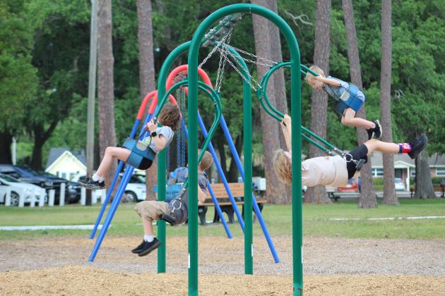 Children enjoy a morning spent at Central Park, challenging each other to swing higher and higher.