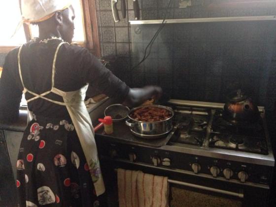 A culinary student at Sonrisa Culinary School and Bakery cooks stew over a stovetop at the school.