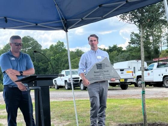 UF/IFAS Nassau County Extension Director Taylor Clem carries a plaque honoring Rebecca L. Jordi, for whom the new extension office is named.