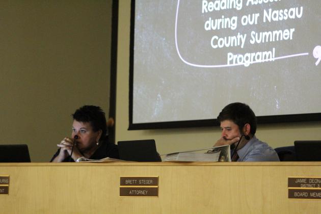 Superintendent Kathy Burns and attorney Brett Steger watch a video presentation from the district on the 2022 summer school session. Photo by Holly Dorman.