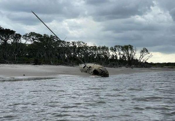 An abandoned sailboat half buried in the sand near Tiger Island will soon be removed and disposed of. Photo courtesy of Nassau County Board of County Commissioners.