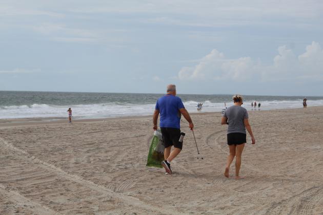 Volunteers keep an eye out for litter as they wander up Main Beach. Holly Dorman/News-Leader