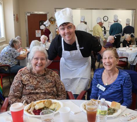 Fernandina Beach Mayor-elect Bradley Bean serves a Thanksgiving feast to Miss Betty (left) and Miss Marcia.