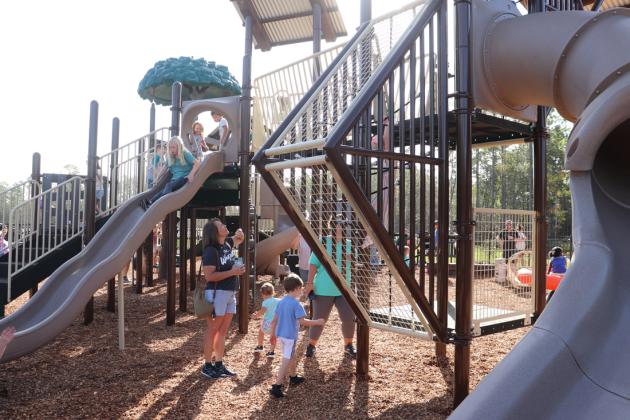 Families enjoy the new playground equipment after the ribbon-cutting ceremony.