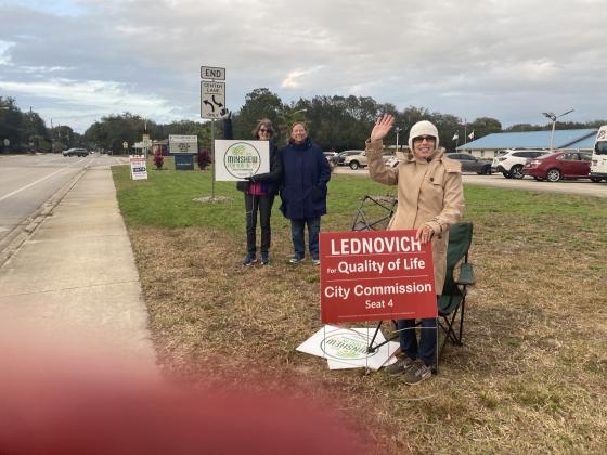 Election supporters wave at voters as they turn into Lighthouse Bible Baptist Church..