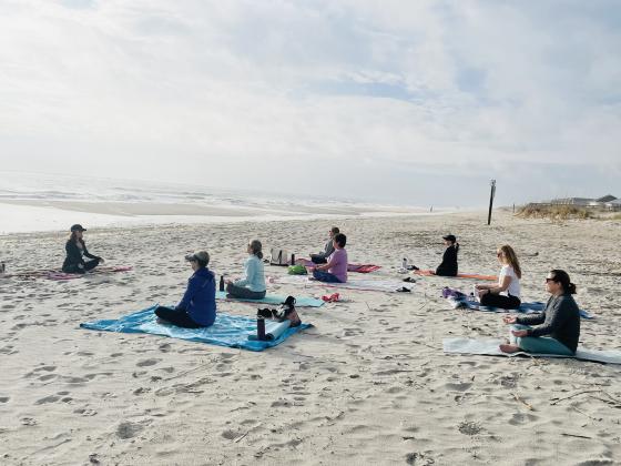 Deb Cunningham starting her Sunday morning beach yoga class.
