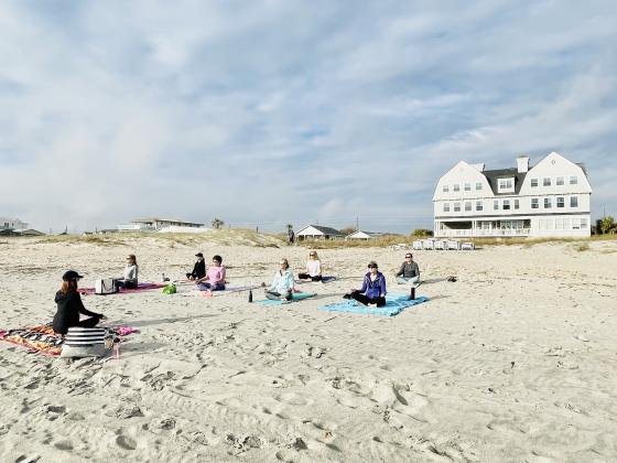 Beach yoga class in front of Elizabeth Point Lodge.