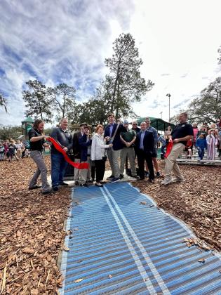 Betty Berkman, along with city officials and her family, cuts the ribbon on a park built with her contribution. The park was named to honor her late husband David, and was dedicated on his birthday. “David was the most wonderful, loving, caring person I’ve ever known,” she said. “He cared about people and especially this community. He would love this playground and the joy it will give to so many children.” Submitted photo