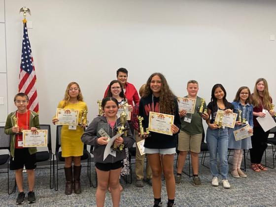 Spelling Bee school champions display their awards.