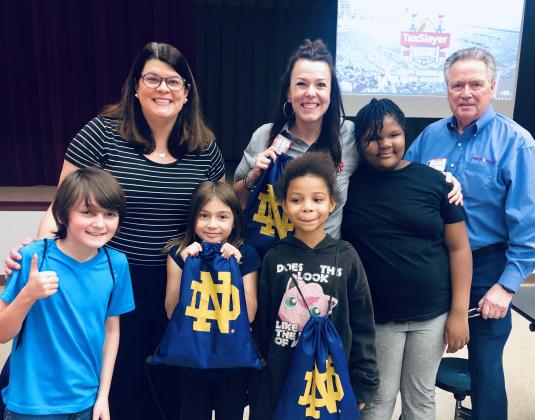 Pictured are, back row from left, Maurie Dugger, Amelia Island Convention &amp; Visitors Bureau; Katie Cox, Gator Bowl; Gil Langley, Amelia Island Convention &amp; Visitors Bureau; and, first row, students from Hilliard Elementary School. Submitted photo
