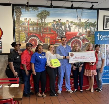 Pictured are, from left, Firehouse Subs Fernandina Beach General Manager Erica Melton, Firehouse Subs District Manager Katie Lott, Barnabas Community Health worker Quashana Levy, Barnabas nurse practicioner Megan Cagle, Barnabas front office manager and EMT Kevin Sharkey, Barnabas Health Services manager Michele VandenBossche, Barnabas President and CEO Jamie Reynolds and Firehouse Subs Catering and Special Events manager Cindi Ross. Photo by Sean Rosenthal