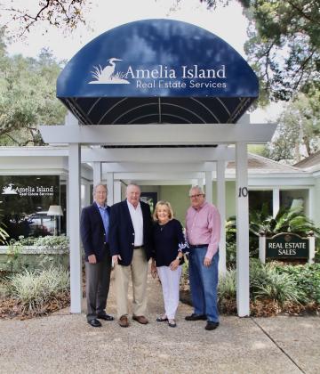 The staff and realtors of Amelia Island Real Estate stand proudly in front of their office.  Photo by Leah Jones/News-Leader