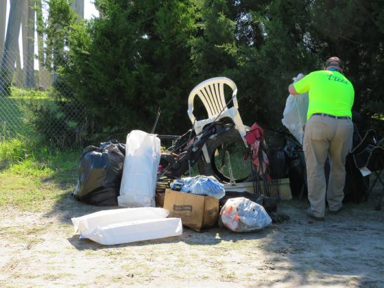 Volunteers clean up litter under the Shave Bridge, where drivers without their loads tied down often lose them over the railing. Photo by Holly Dorman/News-Leader