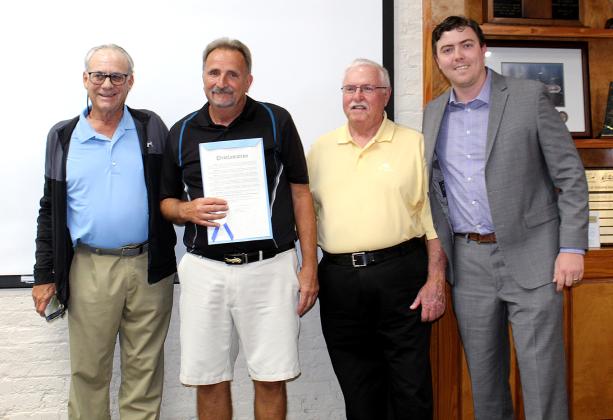 Ron Ferrell, flanked by Friends of the Fernandina Beach Golf Club President Lee Murray and golf club member Mike Meadows, receives a proclamation from Mayor Bradley Bean in recognition for signs he built at the course. Photo by Beth Jones/News-Leader