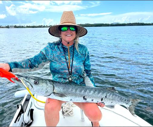 Harriet Durham, top, was tired of seeing a large barracuda steal her fish, so she picked up a nearby spinning rod and reel rigged with a tube lure and caught that pesky barracuda. Special photo