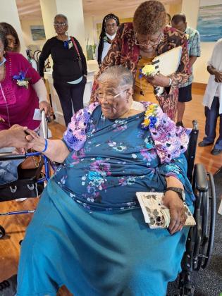 Fellow classmate Elizabeth Harvey Robinson presented a knitted shawl and hat to Johnnie Mae Van. Photo by Maybell Kirkland