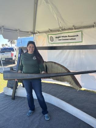 Ana Nader, Florida Fish and Wildlife Conservation Commission Marine Mammal Scientist, holding a right whale baleen, behind her a gray whale baleen, on the floor a whale mandible. Photo by Sean Rosenthal/News-Leader
