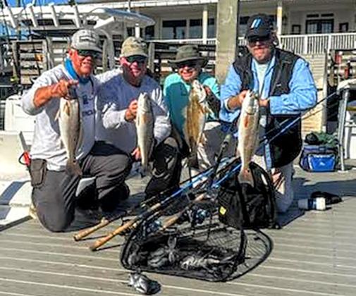 Terry Lacoss, Greg Cook, Jack Healan and Bill Fassbender, from left, are pictured with a limit catch of inshore redfish and off-shore black sea bass. Submitted photo