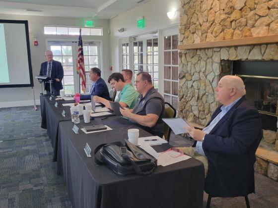 Financial consultant Mark Galvin, standing, addresses the Fernandina Beach City Commission, from left, Darron Ayscue, James Antun, Mayor Bradley Bean, David Sturges and Chip Ross, about the steps that need to be taken to ask voters to approve a bond. In order to get the matter on the November ballot, the language put to voters has to be approved by May 17. Photo by Julia Roberts/News-Leader