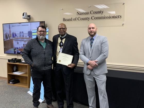 William Johnson, center, of the Road and Bridge Department was acknowledged at Wednesday’s Nassau County Board of County Commissioners meeting for 30 years of service to the county. Presenting the award were Darren Marsh, interim road director, left, and Taco Pope, county manager, right. Photo courtesy of Sabrina Robertson/Nassau County Board of Commissioners