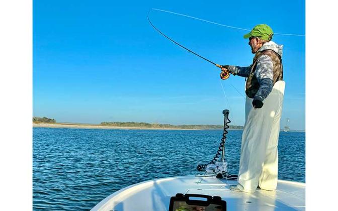 Capt. Scott Barmby is pictured sending a favorite fly pattern from the bow while locating schooling winter sea trout. Photo by Terry Lacoss
