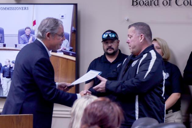 Vice Chairman A.M. “Hupp” Huppman shakes hands with and presents a proclamation to Nassau County Animal Care and Control staff member T. Maguire. The Nassau County Board of County Commissioners proclaimed next week, April 14-20, as Animal Care and Control Appreciation Week in the county. Photo by Ashley Chandler